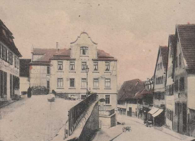 Eine alte Postkarte zeigt ein Haus in der Nürtinger Altstadt. Das Haus hat viele Fenster mit Vorhängen. Das Hausdach hat einen schön verzierten Giebel.