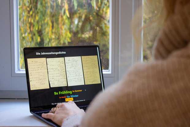 Eine Person sieht sich an einem Laptop die Manuskripte zu Hölderlins Jahreszeitengedichten an.