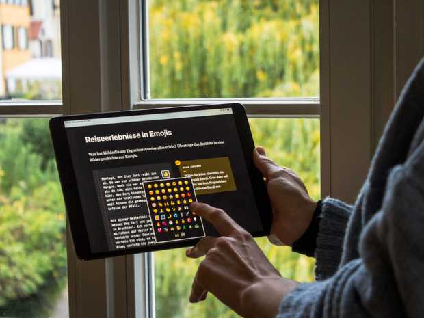 Eine Person steht am Fenster und wählt auf einem Tablet bunte Emojis zu Hölderlins Reiseerlebnissen aus.